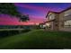 A backyard scene with lush green lawn, patio set, and vibrant dusk sky views at 4099 Starflower Rd, Castle Rock, CO 80109