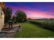 Expansive backyard with manicured lawn, mature trees, and stone patio, perfect for outdoor entertaining at 4099 Starflower Rd, Castle Rock, CO 80109