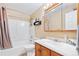 Bright bathroom with a tub and shower combo, framed mirror, and a classic wood vanity with ample storage at 4099 Starflower Rd, Castle Rock, CO 80109