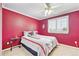 Bedroom with bold magenta walls, neutral carpet, plantation shutters, and queen size bed at 4099 Starflower Rd, Castle Rock, CO 80109