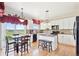 Bright eat-in kitchen with white cabinets, granite counters, island, and beautiful views at 4099 Starflower Rd, Castle Rock, CO 80109