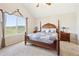Main bedroom with four-poster bed, vaulted ceiling, and stunning views from the large window at 4099 Starflower Rd, Castle Rock, CO 80109