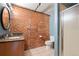 Modern bathroom featuring exposed brick wall and tiled flooring at 1515 N Ogden St # 7, Denver, CO 80218