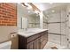 Modern bathroom boasts double vanity, sleek glass-enclosed shower, exposed brick wall, and contemporary fixtures at 1515 N Ogden St # 7, Denver, CO 80218