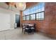 Loft dining area with a round table, brick wall, and large window at 1515 N Ogden St # 7, Denver, CO 80218