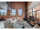 Bright living room with exposed brick, high ceilings, and large windows, offering ample natural light at 1515 N Ogden St # 7, Denver, CO 80218