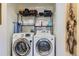 Bright laundry room featuring side-by-side washer and dryer with shelving above at 1897 S Buchanan Cir, Aurora, CO 80018