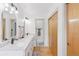 Elegant bathroom with double sinks, a large mirror, wood floors, and modern fixtures at 8484 E Radcliff Ave, Denver, CO 80237