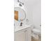 This bathroom features a modern sink, round mirror, and a toilet with a sleek, stylish design at 8484 E Radcliff Ave, Denver, CO 80237