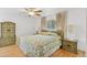 Charming bedroom featuring wood floors, a ceiling fan, and a large floral patterned bedspread at 8484 E Radcliff Ave, Denver, CO 80237