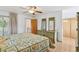 Comfortable bedroom with light wood floors, ceiling fan, dresser with mirrors, and a sliding glass door to a balcony at 8484 E Radcliff Ave, Denver, CO 80237