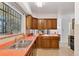 Functional kitchen featuring wood cabinetry, a stainless steel sink, and a view out to the backyard at 8484 E Radcliff Ave, Denver, CO 80237