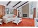 Inviting living room features a brick fireplace, carpeted floor, and large windows offering natural light at 8484 E Radcliff Ave, Denver, CO 80237