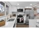 Beautiful modern kitchen with stainless steel appliances, white cabinets, and quartz countertops at 8051 Clarkson Ct, Denver, CO 80229