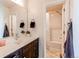 Bright bathroom features a dark vanity, modern faucet, and a shower and tub combo with a beige shower curtain at 10152 Southlawn Cir, Commerce City, CO 80022