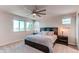 Inviting bedroom featuring a ceiling fan, large windows with beautiful outside views, and stylish decor elements at 10152 Southlawn Cir, Commerce City, CO 80022
