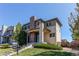 Inviting two-story home featuring stone accents, manicured lawn, and a welcoming front entrance at 10152 Southlawn Cir, Commerce City, CO 80022