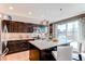 Modern kitchen featuring a kitchen island, dark cabinets, and a sliding glass door at 10152 Southlawn Cir, Commerce City, CO 80022