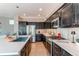 Well-equipped kitchen featuring a kitchen island, stainless steel appliances, and dark cabinets at 10152 Southlawn Cir, Commerce City, CO 80022