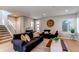 Inviting living room with modern furnishings and a large clock accenting the light gray walls at 10152 Southlawn Cir, Commerce City, CO 80022