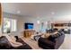 Bright living room featuring two sofas, a large TV, and an open concept layout to the kitchen at 10152 Southlawn Cir, Commerce City, CO 80022