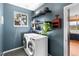 Well-organized laundry room features a window and open shelving, next to the washer and dryer at 26176 Sweetbriar Trl, Evergreen, CO 80439