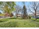 Expansive backyard featuring mature trees and lush greenery, offering a private outdoor space at 835 S Geneva St, Aurora, CO 80247