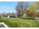 Serene backyard with mature trees, lush grass, and a sense of privacy at 835 S Geneva St, Aurora, CO 80247
