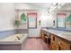 Bathroom featuring a sunken tub, large vanity with double sinks, and pink accents throughout at 835 S Geneva St, Aurora, CO 80247
