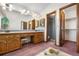 Bathroom with double sinks, wood cabinets, large mirror, and access to shower room and walk-in closet at 835 S Geneva St, Aurora, CO 80247