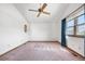 Bright bedroom with ceiling fan, window, and large carpeted area at 835 S Geneva St, Aurora, CO 80247