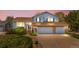 Beautiful two-story home with brick accents, two-car garage, and lush landscaping at twilight at 835 S Geneva St, Aurora, CO 80247