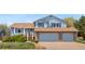 Inviting two-story home with brick accents, an attached two-car garage, and lush front yard landscaping at 835 S Geneva St, Aurora, CO 80247