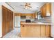 Well-lit kitchen featuring warm-toned cabinetry, sleek appliances, and ample storage space at 835 S Geneva St, Aurora, CO 80247
