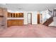 Spacious living room featuring a brick fireplace, wet bar, and staircase at 835 S Geneva St, Aurora, CO 80247