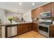 Spacious kitchen featuring stainless steel appliances and brown cabinetry at 11886 E Fair Ave, Greenwood Village, CO 80111