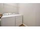 Bright laundry area features a white washer and dryer with a wire shelf above for storage at 11886 E Fair Ave, Greenwood Village, CO 80111