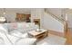 Bright living room features a fireplace, hardwood floors, and access to an open kitchen and staircase at 11886 E Fair Ave, Greenwood Village, CO 80111