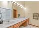 Bathroom featuring a long vanity with dual sinks, large mirror, and a glass-enclosed shower at 4231 S Fairplay Cir # A, Aurora, CO 80014