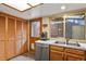 Functional kitchen with a stainless steel dishwasher and double sinks, complemented by ample natural light at 4231 S Fairplay Cir # A, Aurora, CO 80014
