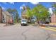 Exterior view of a parking lot surrounded by colorful townhomes and mature trees in a quiet neighborhood at 1662 S Blackhawk Way # A, Aurora, CO 80012