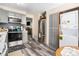 Modern kitchen with stainless steel appliances, light gray cabinets, and washer-dryer closet at 1143 Lamar St # 6, Lakewood, CO 80214