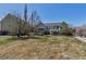 Large backyard with a green lawn, mature trees, and an outdoor patio area at 3545 Cottonwood Cir, Longmont, CO 80504