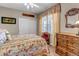 Cozy bedroom showcasing a patterned bed, ornate wooden dresser, and a window at 3545 Cottonwood Cir, Longmont, CO 80504
