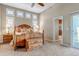 A well lit bedroom with a carpet, ceiling fan, large windows, and ensuite bathroom at 3545 Cottonwood Cir, Longmont, CO 80504