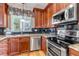 Close up of kitchen features dark cabinets, granite countertops, stainless appliances, and tiled backsplash at 3545 Cottonwood Cir, Longmont, CO 80504