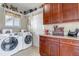 Bright laundry room with cabinets, counter space, and a modern washer and dryer set at 3545 Cottonwood Cir, Longmont, CO 80504