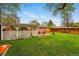 Spacious backyard with a well maintained lawn, mature trees, a patio with covering, and a view of the brick home at 8736 W 46Th Ave, Wheat Ridge, CO 80033