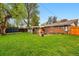 Well maintained backyard, showing the patio, the brick house, with a lush green lawn. The fence is wood, and there is a shed in the corner at 8736 W 46Th Ave, Wheat Ridge, CO 80033