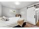A calming bedroom is adorned with a sliding barn door and bright window for natural light at 8736 W 46Th Ave, Wheat Ridge, CO 80033